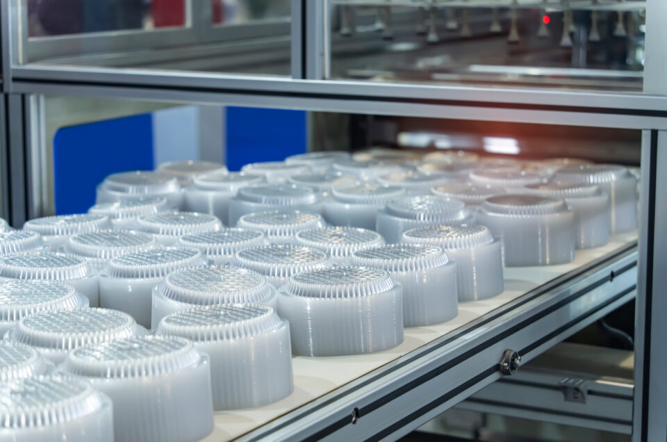 自動プラスチック射出成形機のコンベアベルト上のポリプロピレン食品容器の積み重ね